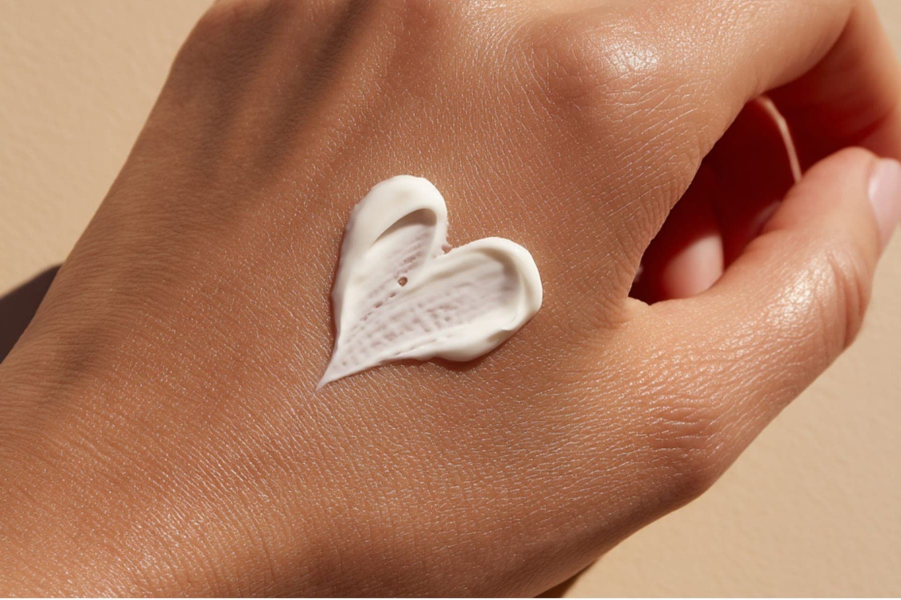 Pflegecreme in Herzform auf der Hand